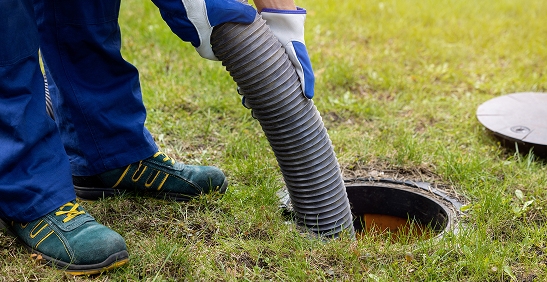 Technician performing outdoor sewage cleaning task